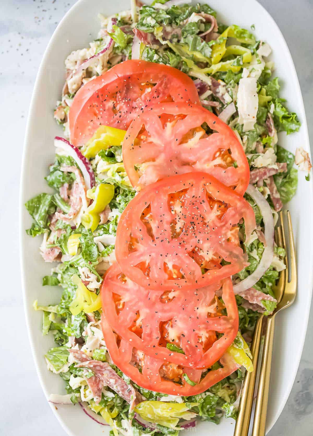 This easy Italian grinder salad recipe with homemade dressing is a trending 15-minute side that'll be a hit at the dinner table. Grinder salad recipe in a plate.