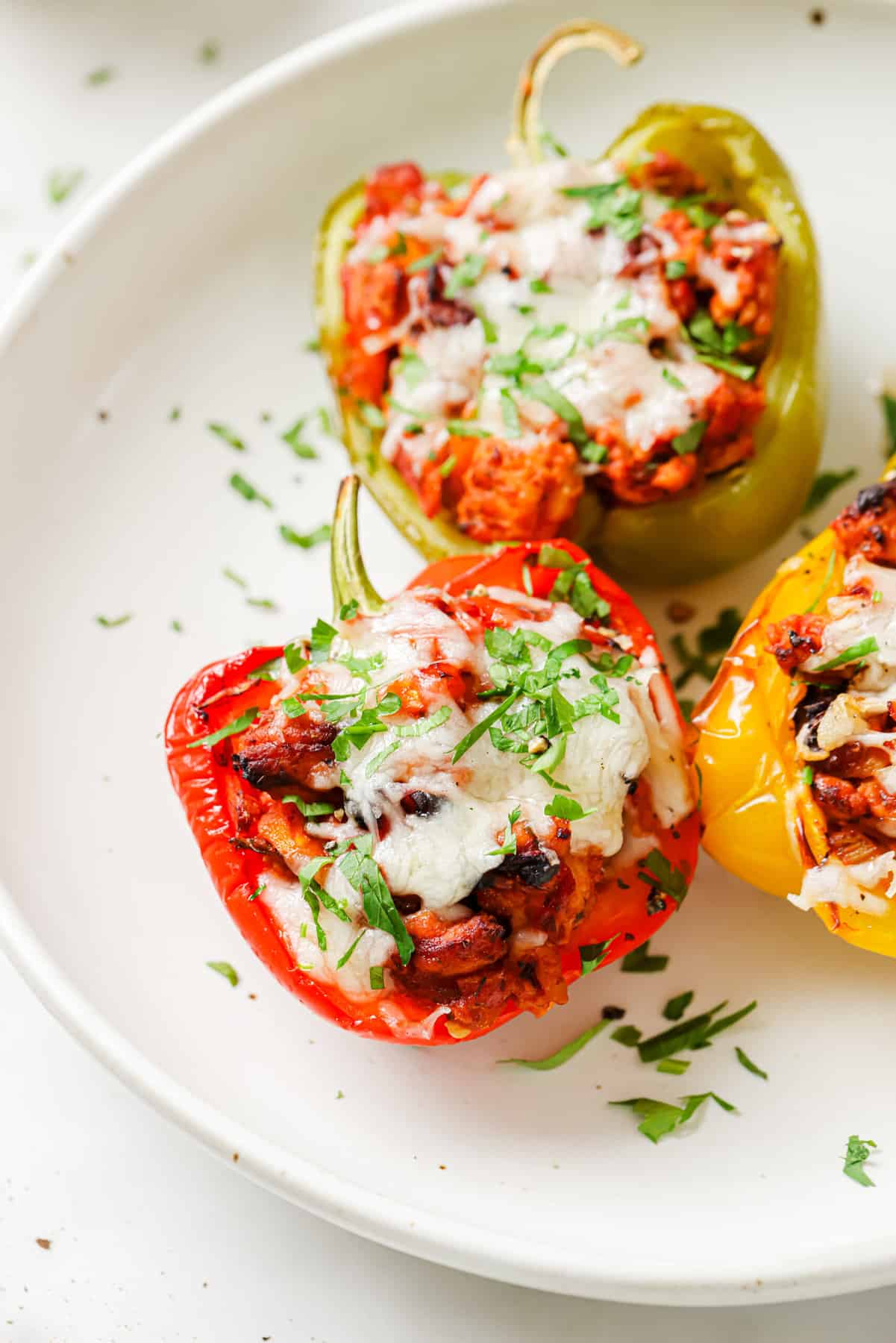 Three stuffed peppers on a plate. 