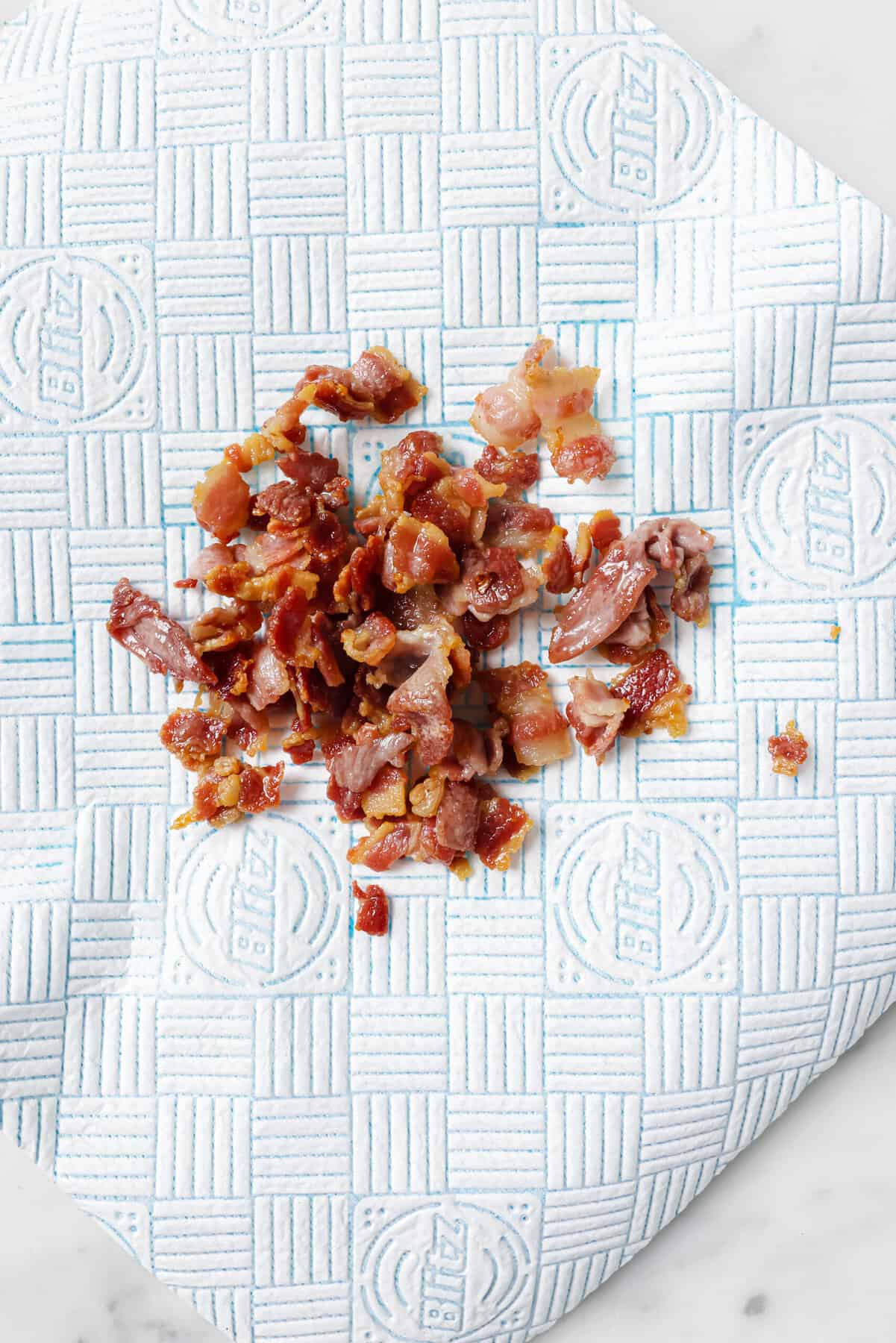 Placing the bacon on a paper-towel lined dish.