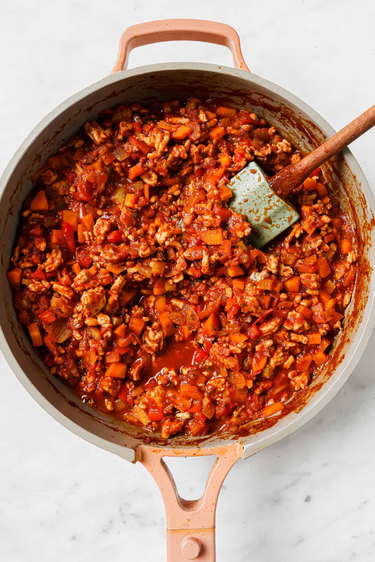These Ground Turkey Stuffed Peppers are a simple dinner recipe filled with rich flavor your family will love. The perfect weeknight meal! Mixing the sauce, ground turkey, veggies, and bacon in the pan.
