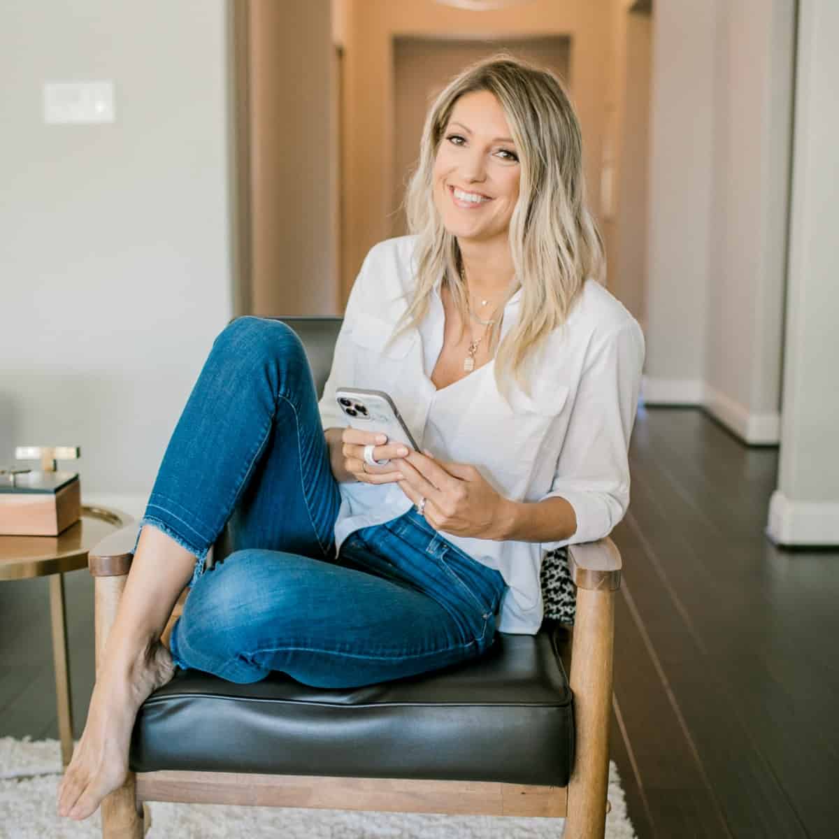 Krista sitting on a chair with phone in-hand