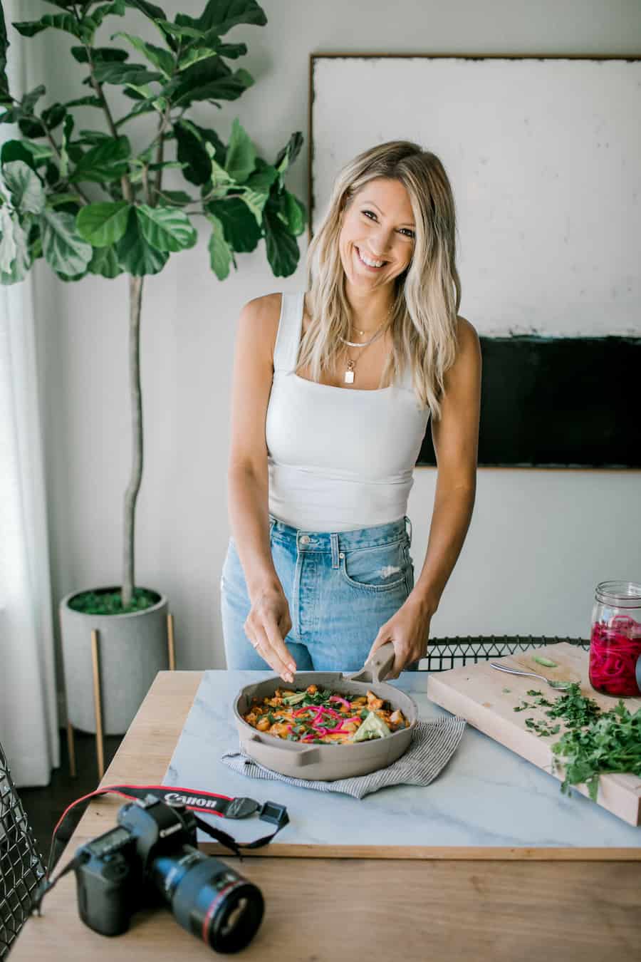 Photo of Krista plating food with a camera on the table