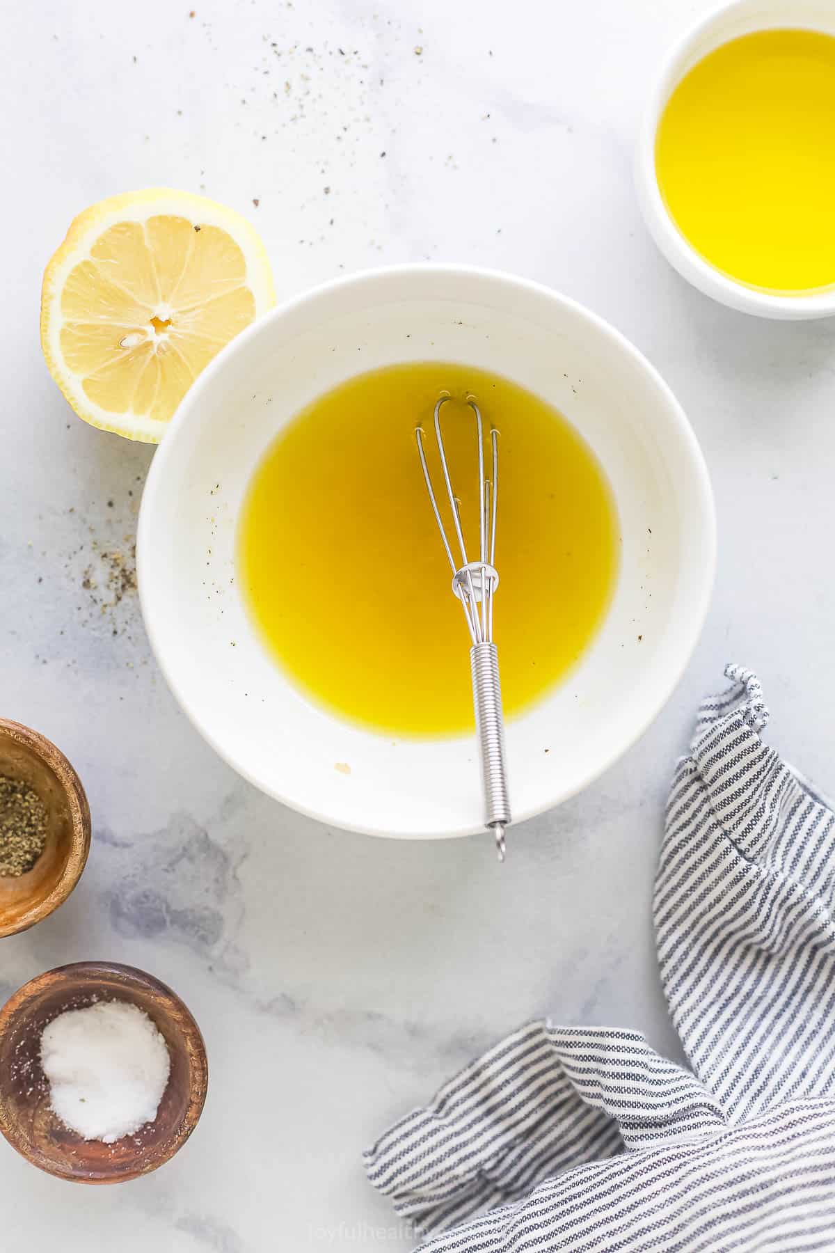 Whisking the dressing in a bowl.