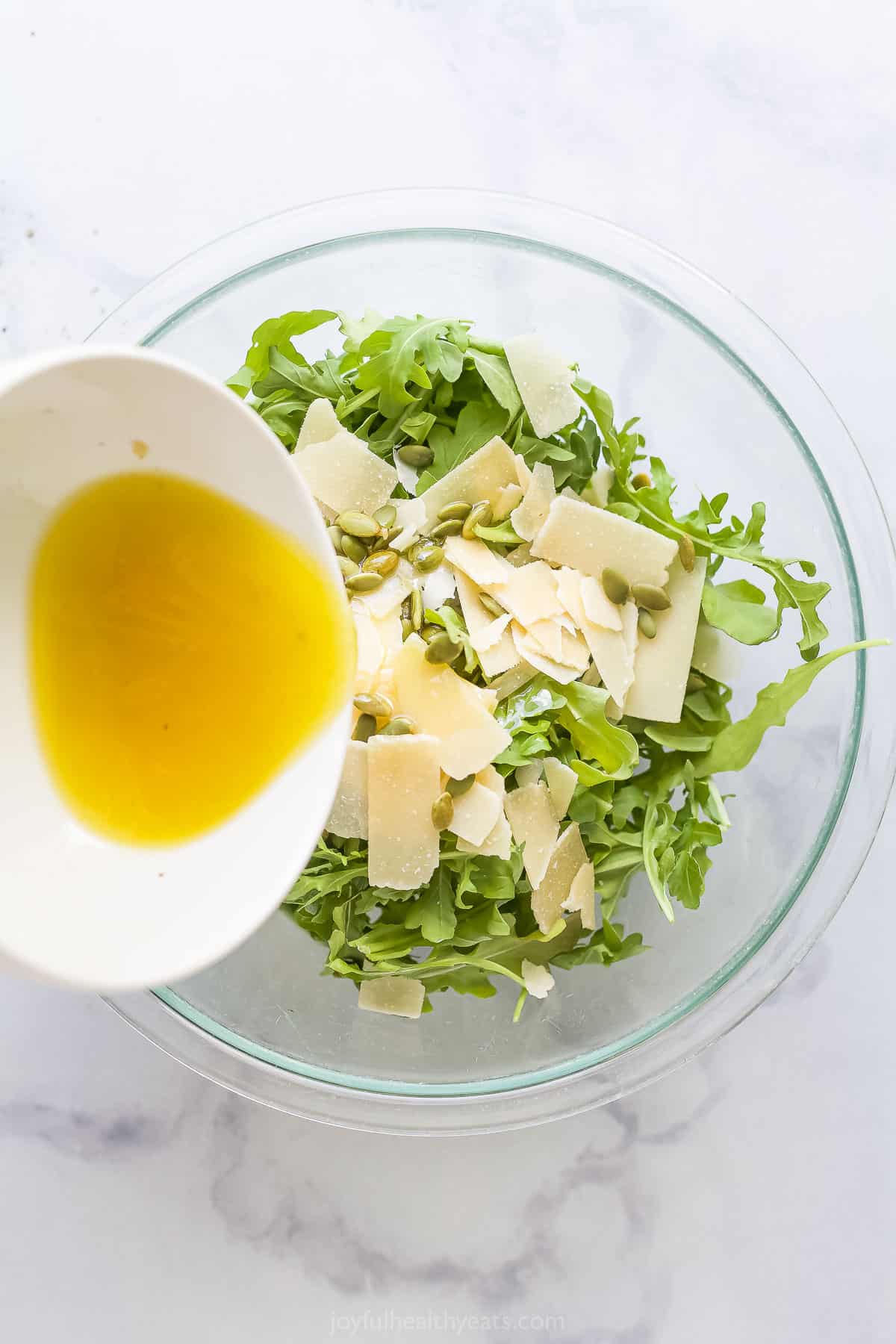 Pouring the dressing over the salad.