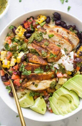 A chicken rice bowl with avocado and pico de gallo.