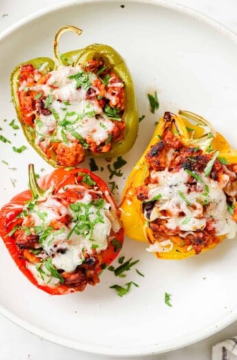 Three Italian stuffed peppers on a plate.