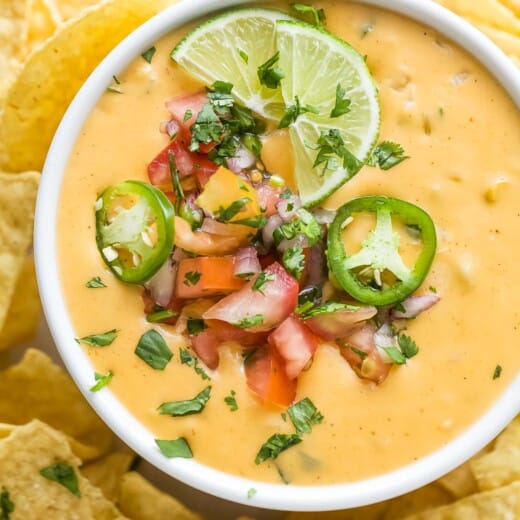 Bowl of chile con queso with pico de gallo.