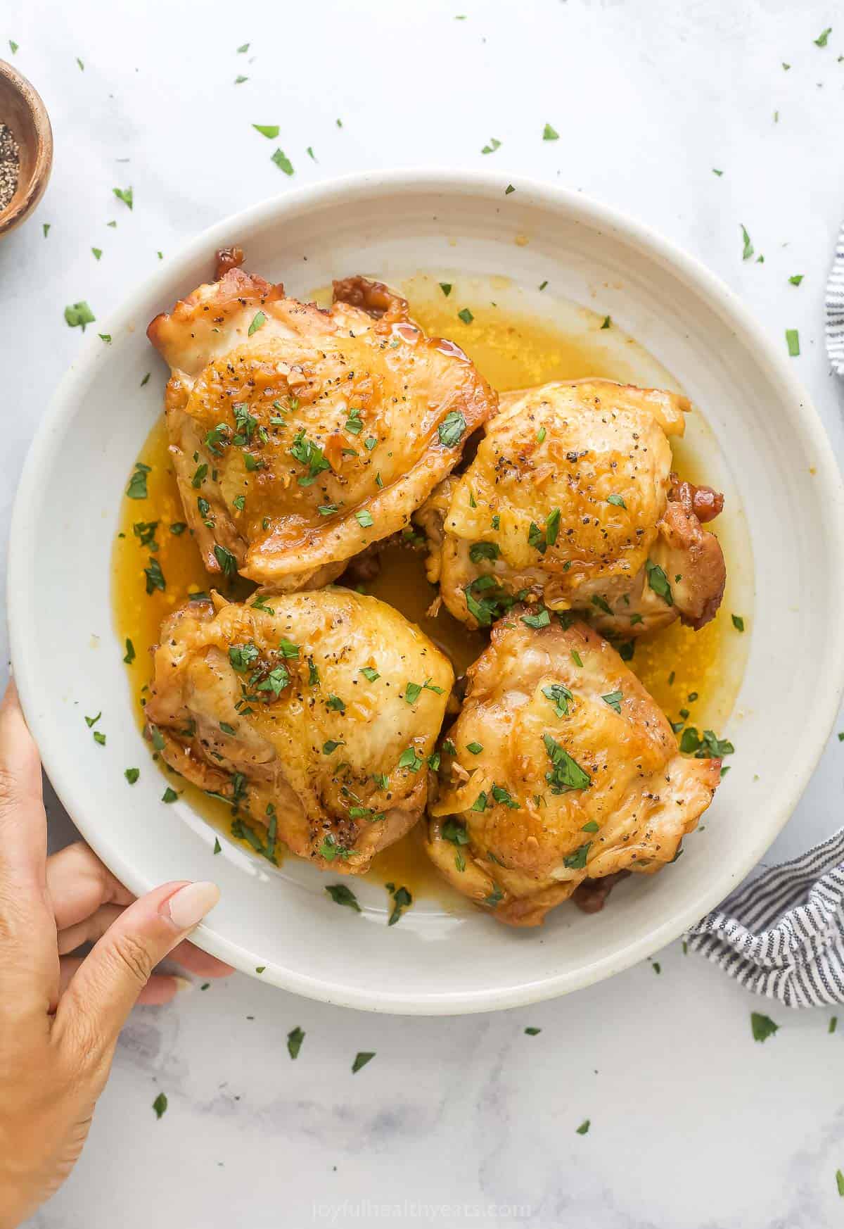Plate of chicken thighs with ،ney garlic sauce. 