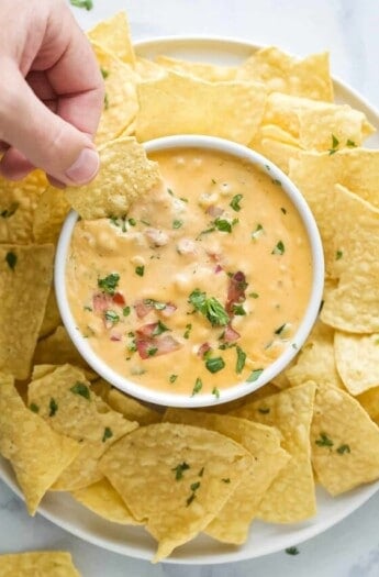 Dipping the corn chip into chile con queso.