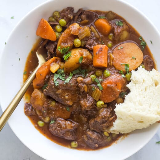 Bowl of instant pot beef stew with a piece of bread.