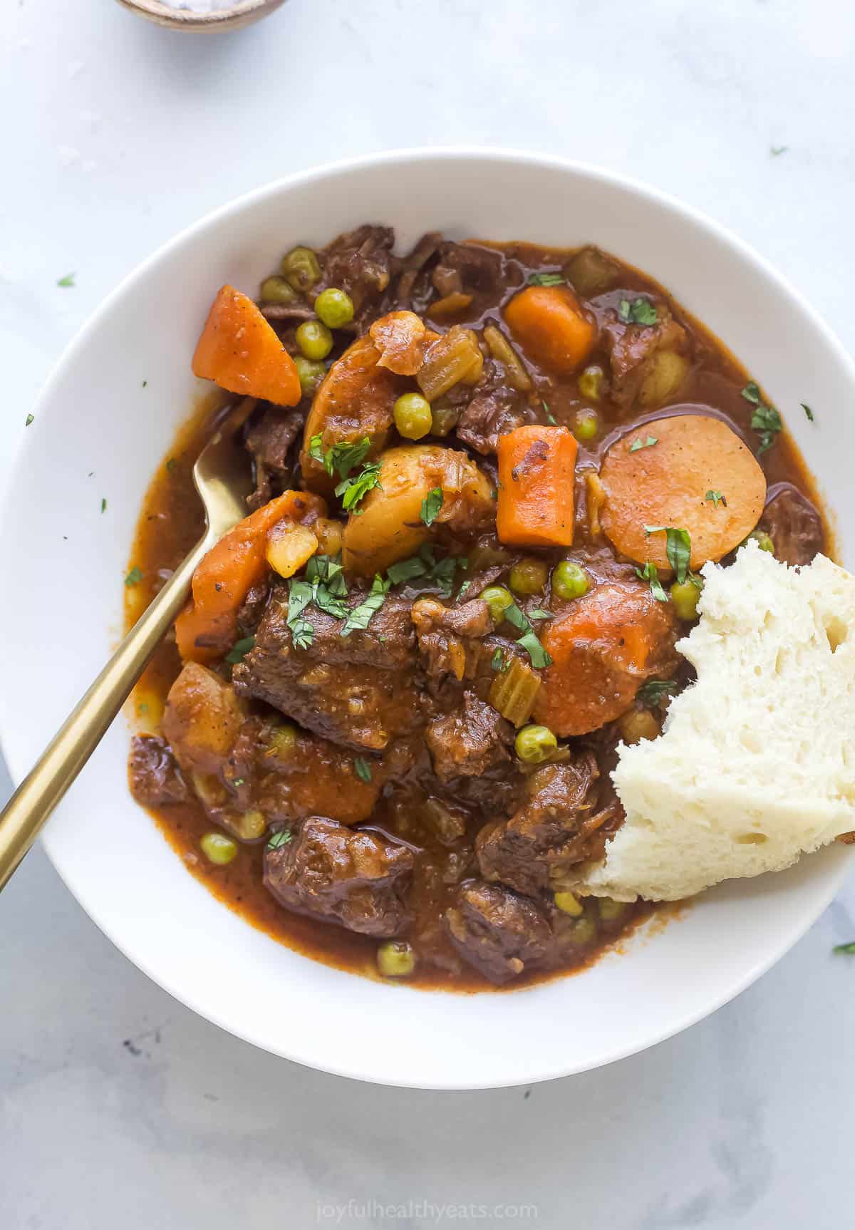 A bowl of instant beef stew with a piece of bread. 