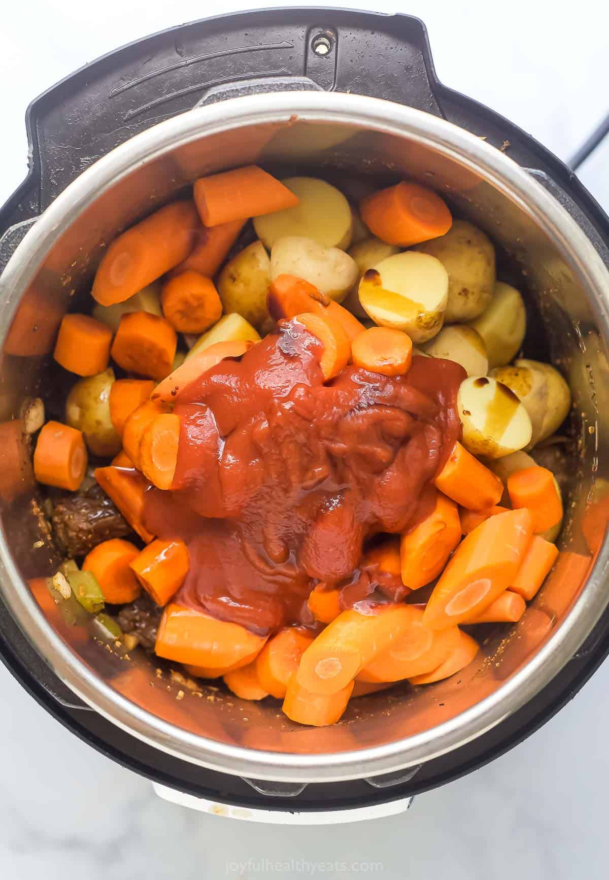 Adding the potatoes, carrots, tomato sauce, and tomato purée. 