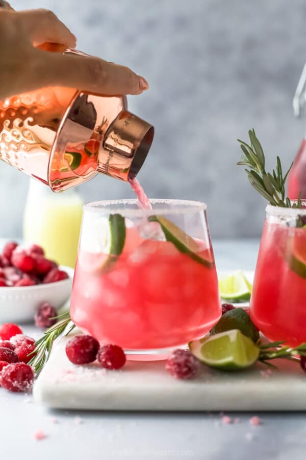 pouring mistletoe margarita into a glass