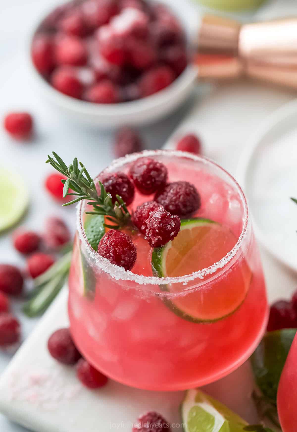 mistletoe margarita in a glass with cranberries