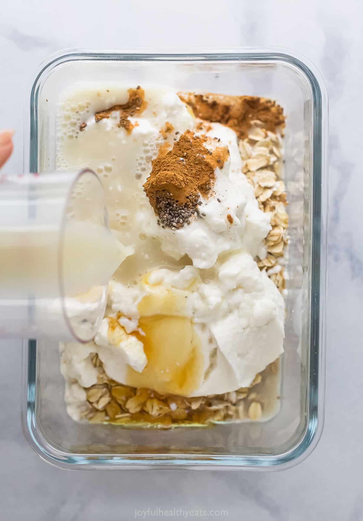 Adding all of the ingredients to a large glass container.