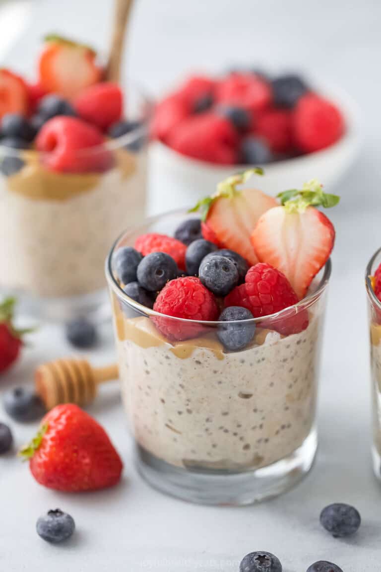 Overnight oats with yogurt in a glass with fresh berries on top.