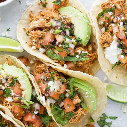 Rotisserie chicken tacos with toppings like cilantro, pico de gallo, and avocado.