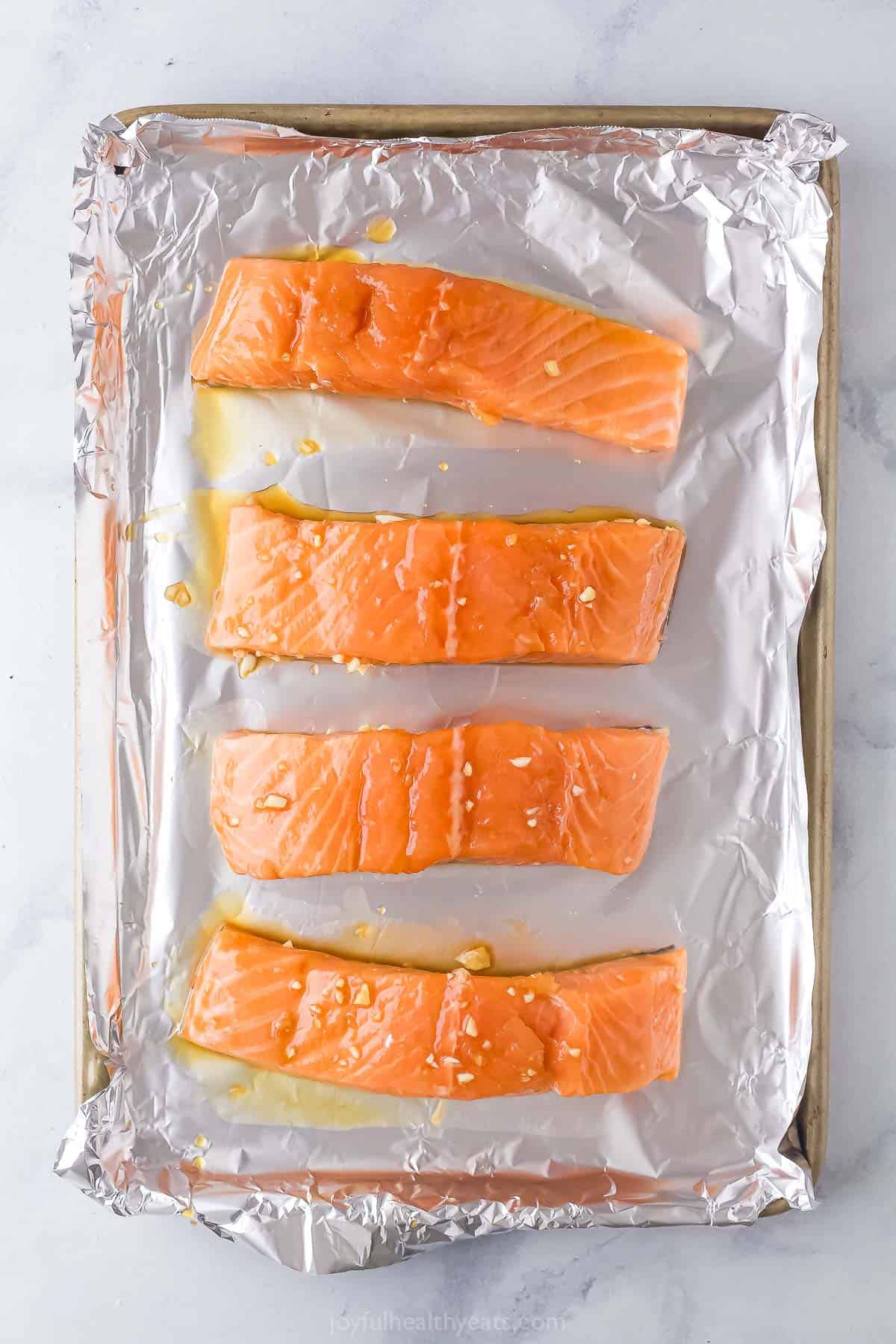 Placing the marinated salmon on the baking sheet. 