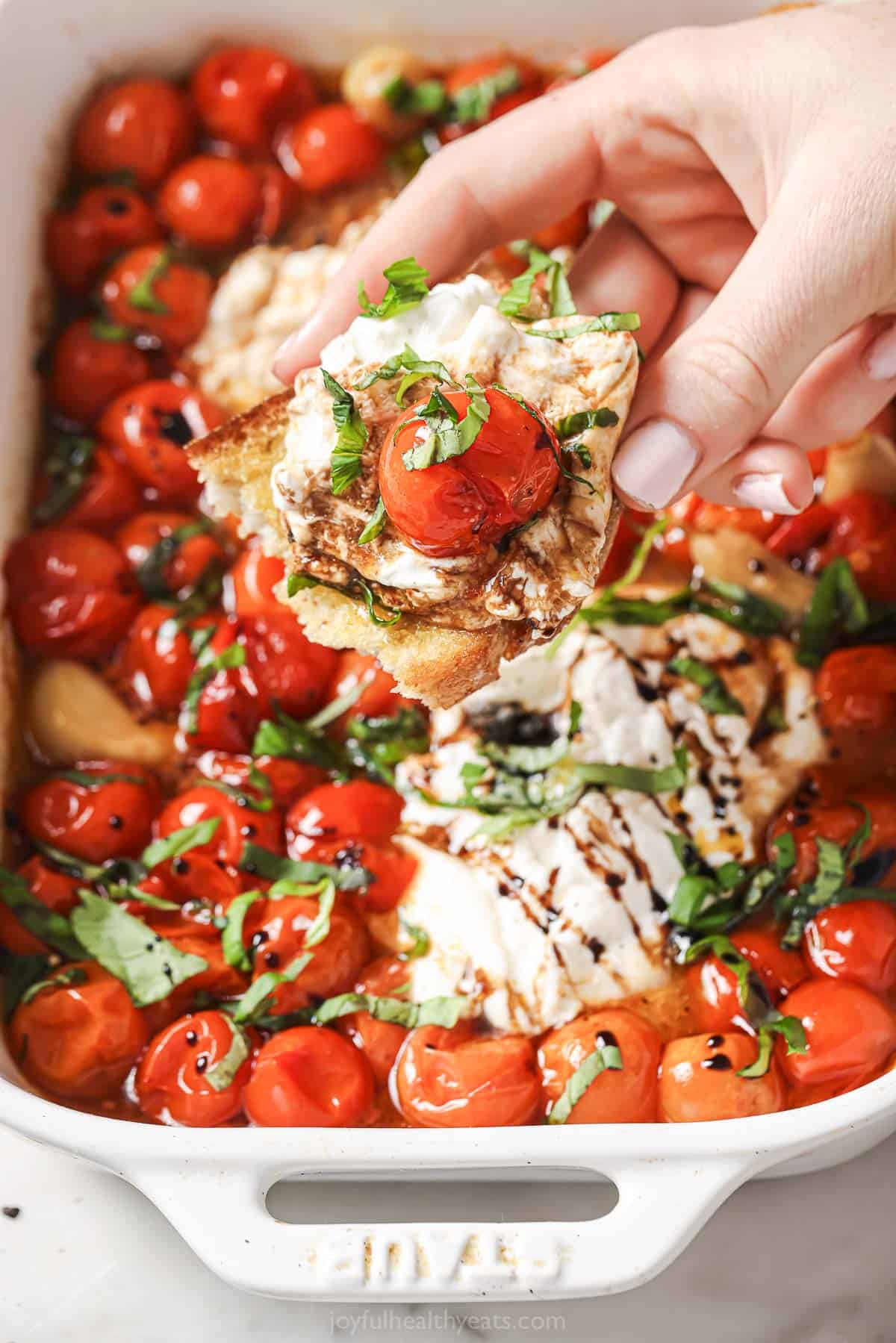 Dipping the sourdough into the caprese with balsamic reduction and fresh basil. 