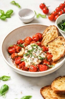 Bowl of burrata caprese with toasted sourdough and balsamic reduction.