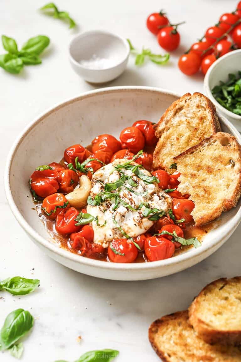Bowl of burrata caprese with toasted sourdough and balsamic reduction.