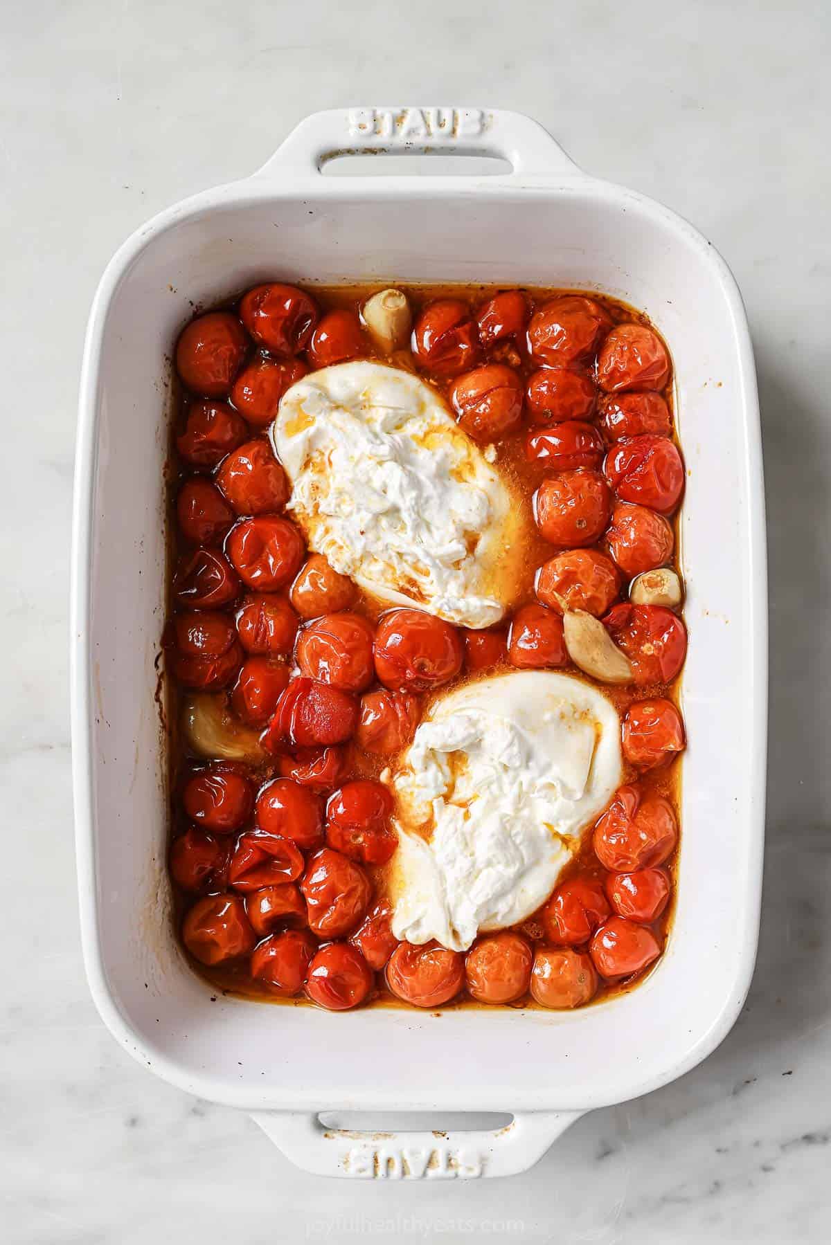Roasted tomatoes and burrata in the baking dish.