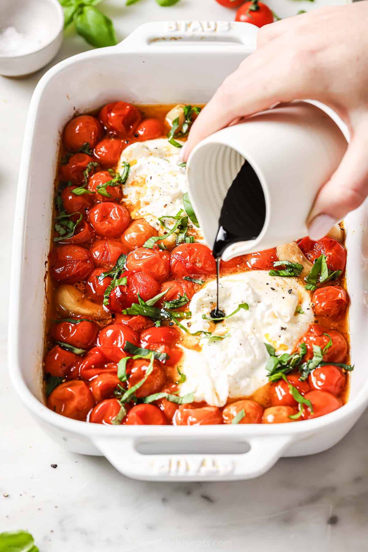 Drizzling balsamic reduction on top.