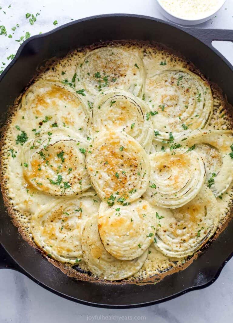 Cheesy creamed onions in the skillet with fresh parsley on top.