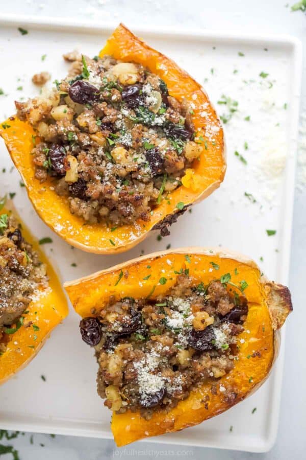 Halved butternut squashes filled with sausage-apple and spinach filling.