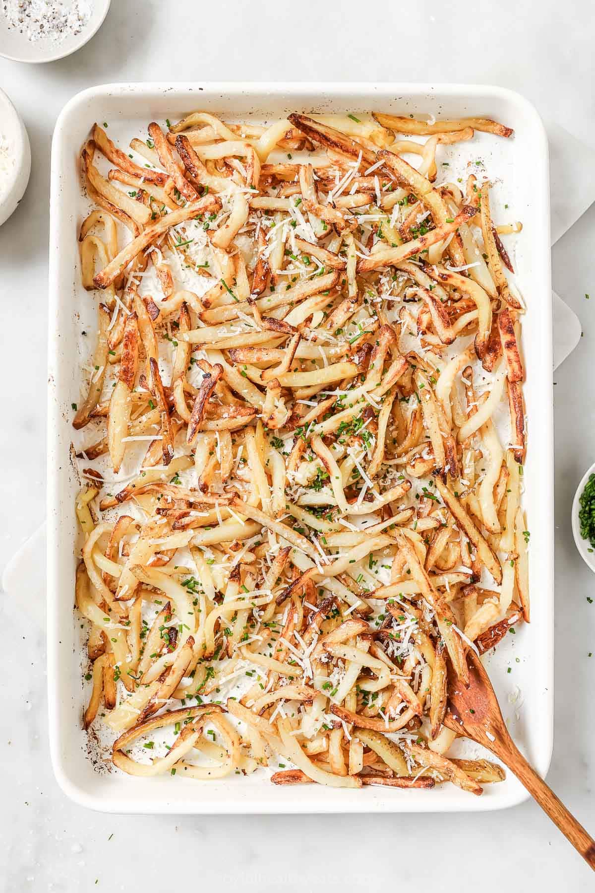 Cheesy Parmesan Truffle Fries are the perfect snack or party app when you’re feeling a little fancy. Baked in the oven and super crispy! Overhead view of Parmesan truffle fries on pan