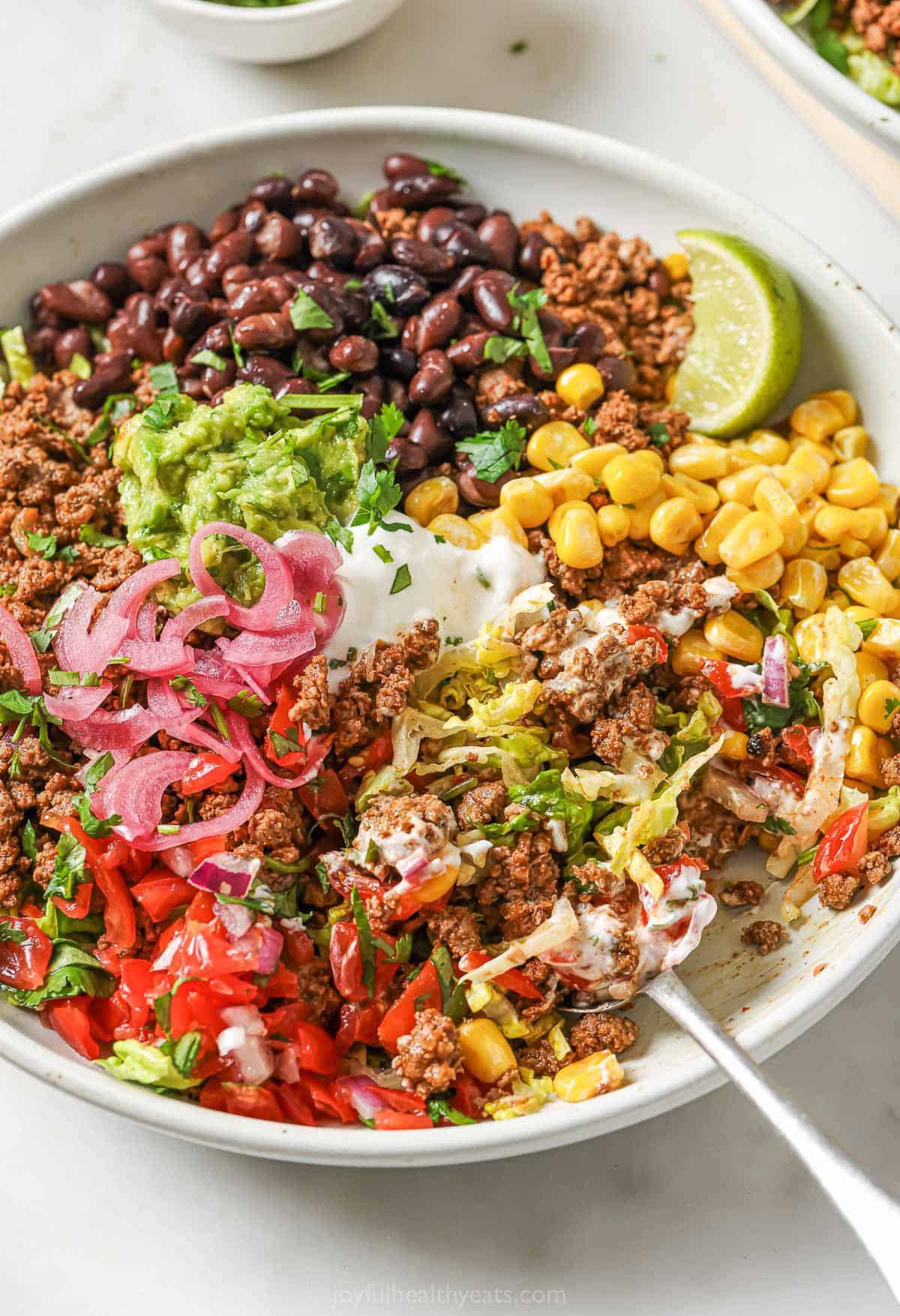 Taco salad bowl with black beans, beef, and corn