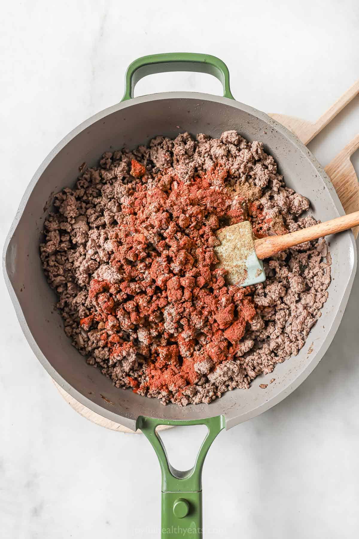 Seasonings added to ground beef in skillet