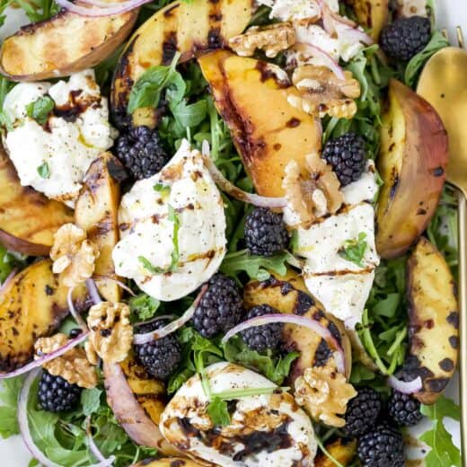 Overhead view of burrata and grilled peach salad on platter