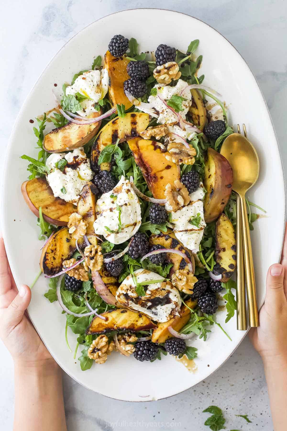 Overhead view of burrata and grilled peach salad on platter