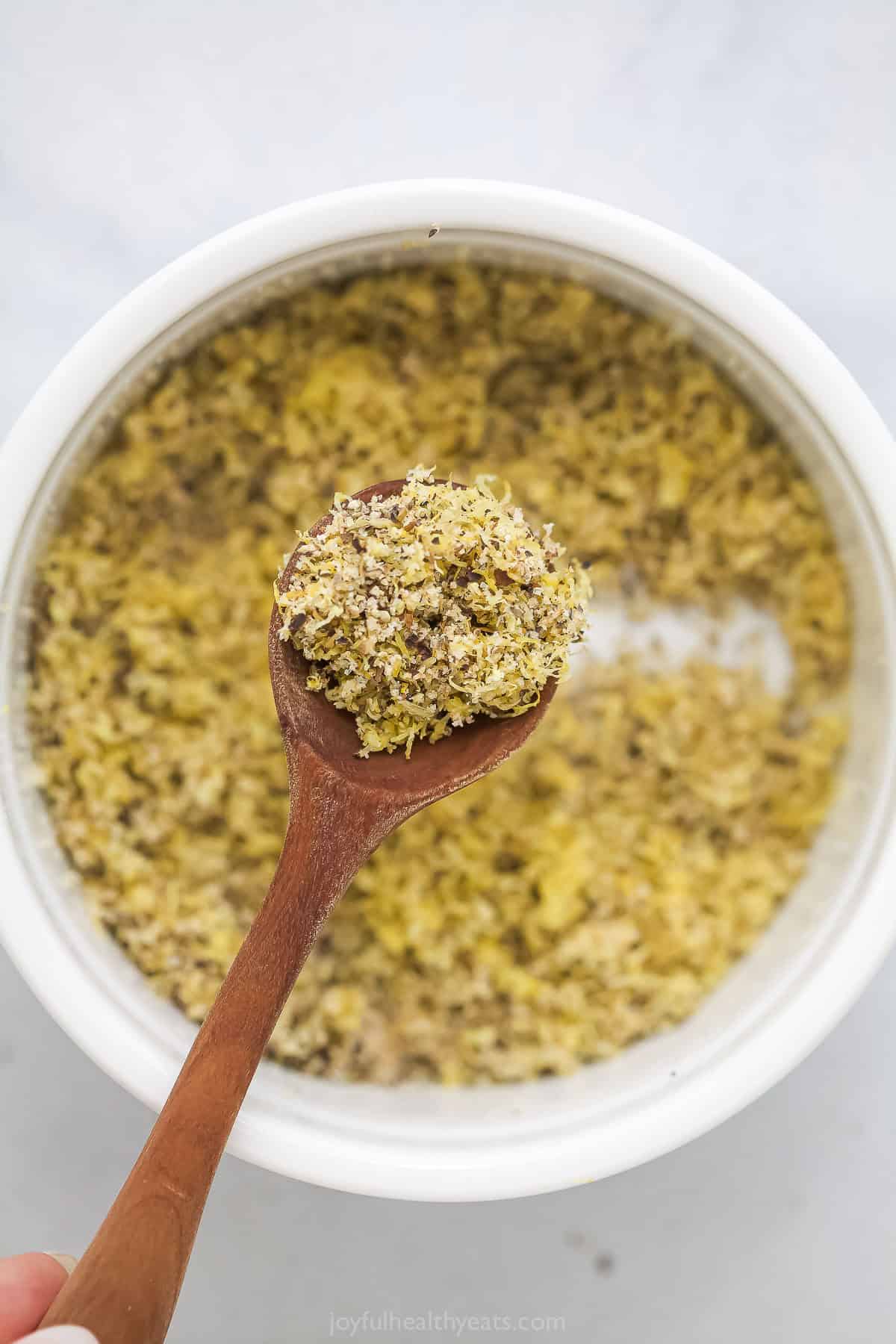 Add a pop of citrus to chicken, seafood, and more with this easy homemade Lemon Pepper Seasoning. It's so much tastier than store-bought! Spoonful of homemade lemon pepper seasoning held over bowl