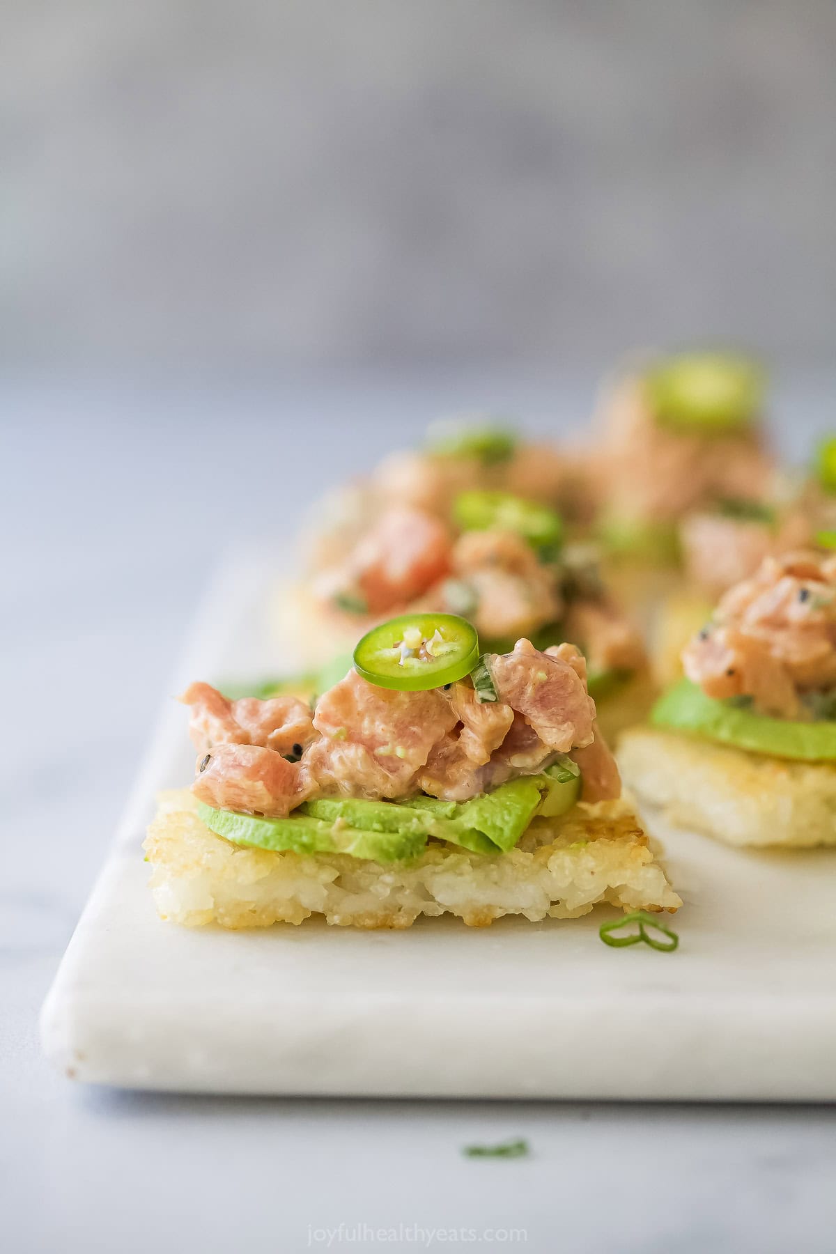 This Spicy Tuna Crispy Rice is a Nobu copycat that’s sure to impress! It’s easy to make, with ahi tuna topping crispy cubes of sushi rice. Copycat spicy tuna crispy rice bites on serving board