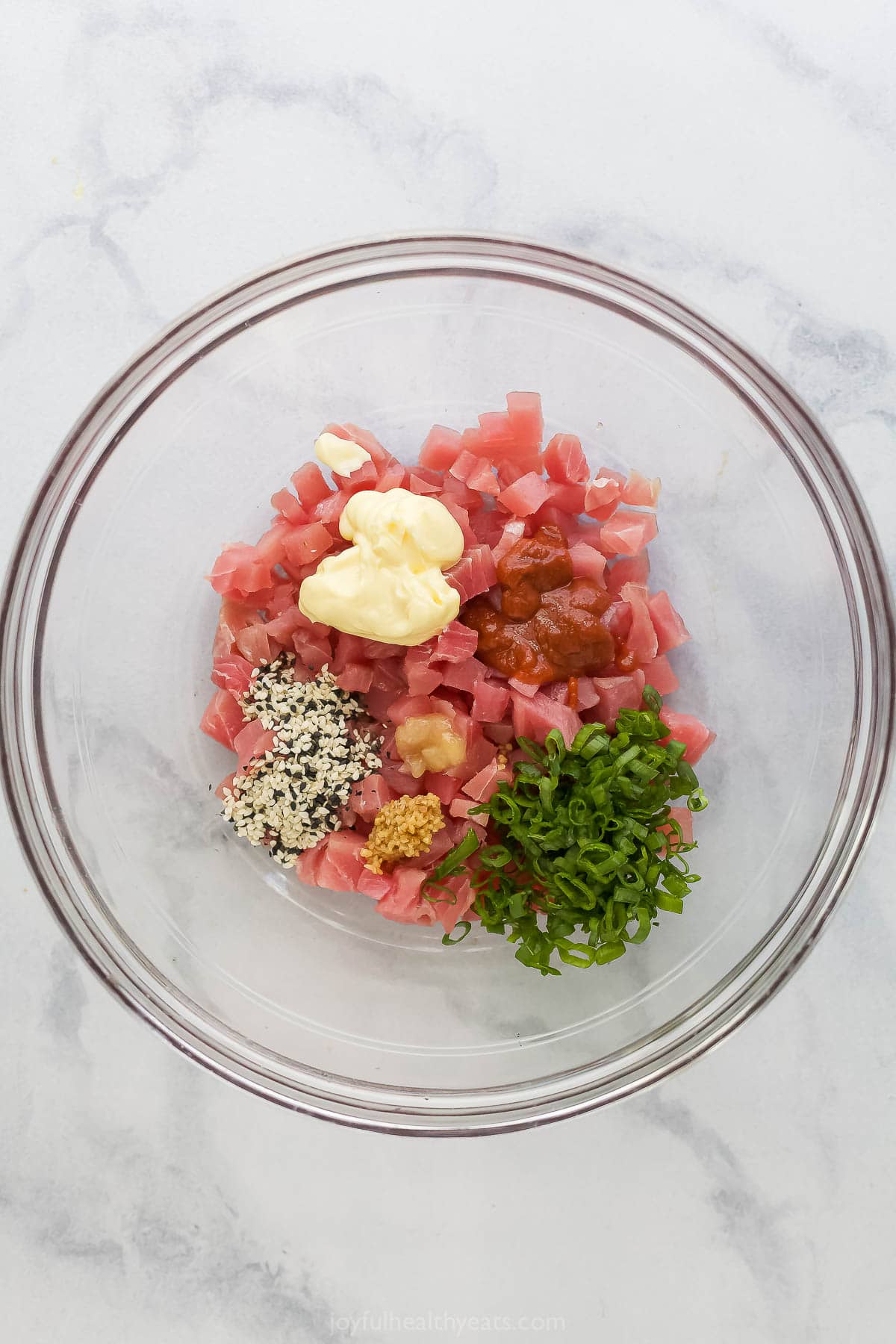 Overhead view of ingredients for spicy tuna in bowl before mixing