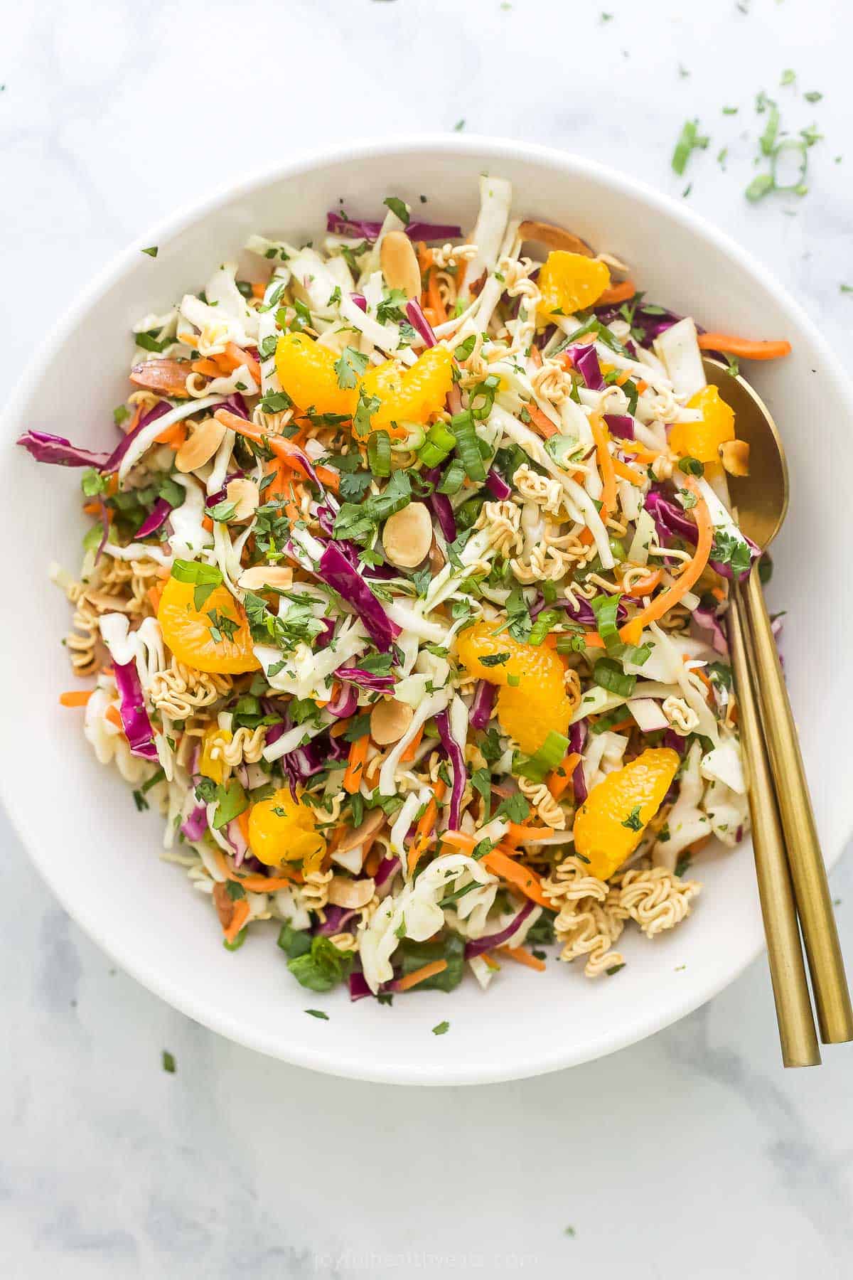 Crunchy, crisp, and sweet Ramen Noodle Salad is a classic! I’ve given it a more modern spin, but it still has that familiar flavor you love. Overhead view of ramen noodle salad in bowl with gold spoons