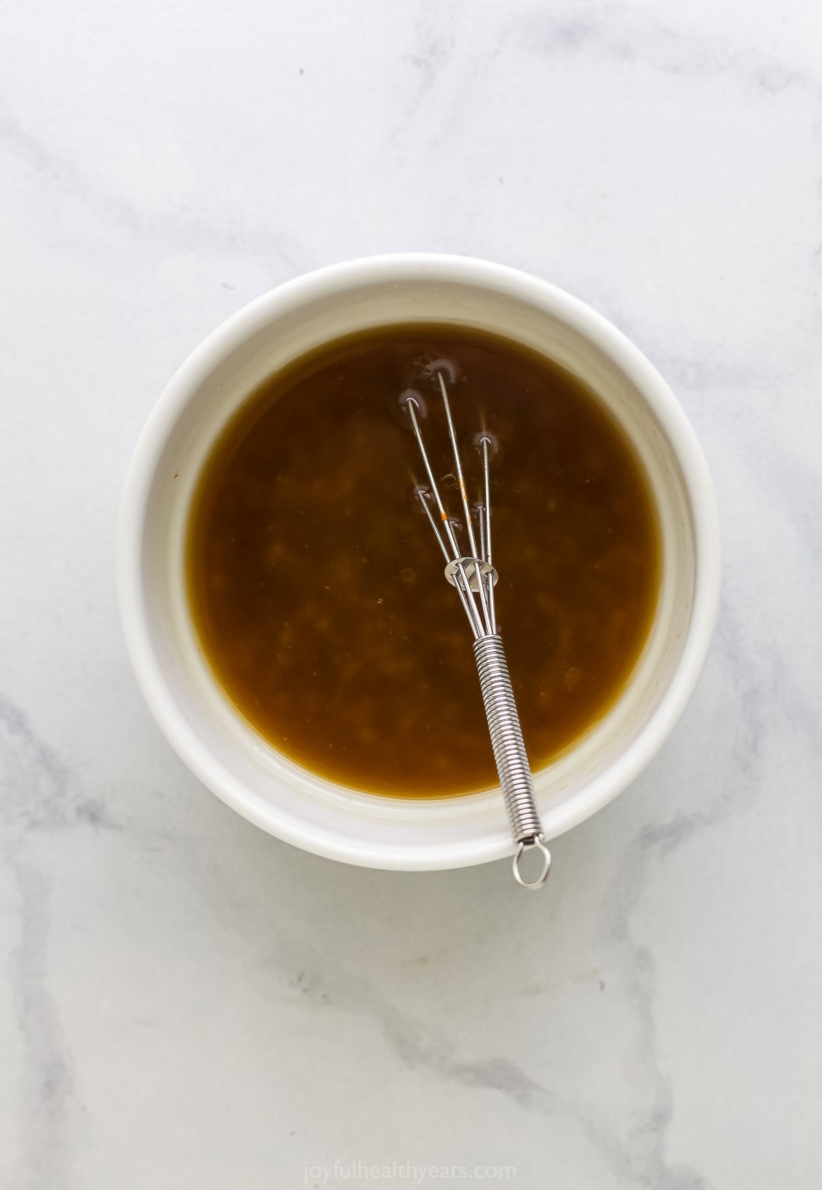 Crunchy, crisp, and sweet Ramen Noodle Salad is a classic! I’ve given it a more modern spin, but it still has that familiar flavor you love. Overhead view of dressing for ramen noodle salad in bowl with whisk