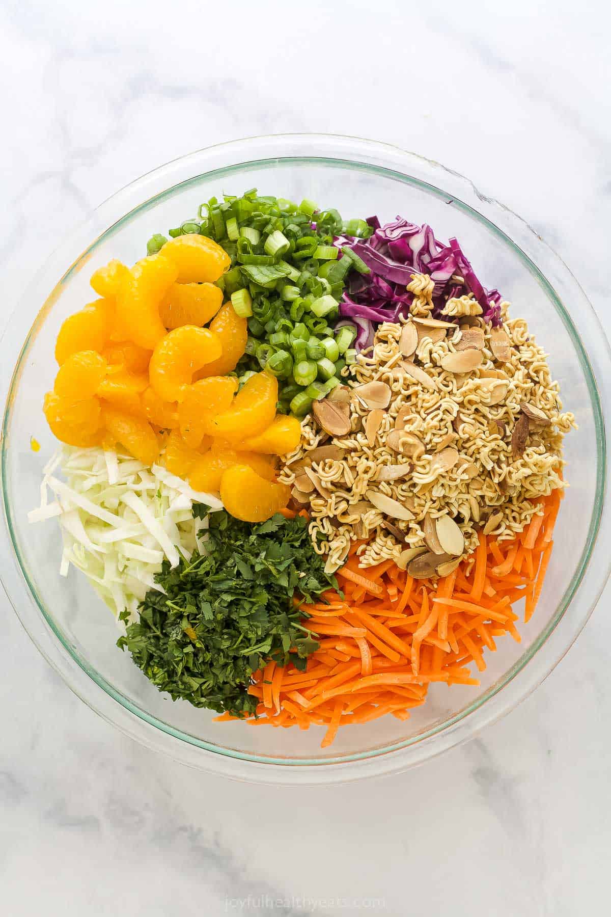 Crunchy, crisp, and sweet Ramen Noodle Salad is a classic! I’ve given it a more modern spin, but it still has that familiar flavor you love. Overhead view of bowl with ingredients for ramen noodle salad