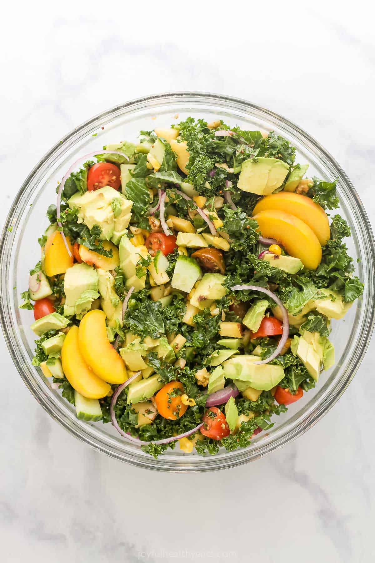 With sweet corn, peaches, tomatoes, grilled chicken and honey mustard dressing, this summer salad recipe is the perfect patio dinner! Overhead view of summer salad in glass bowl