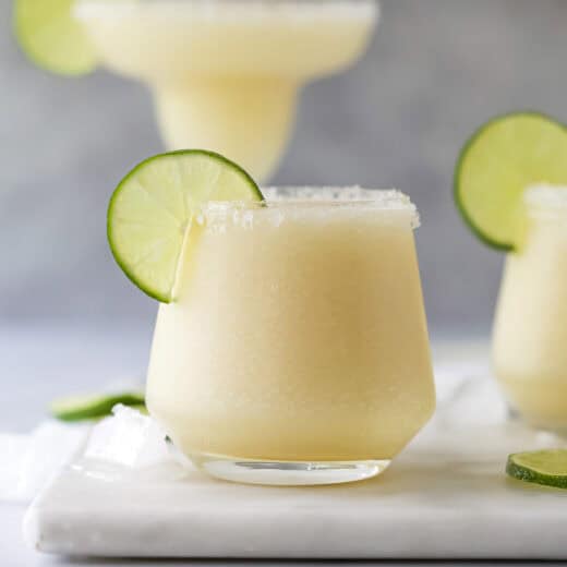 Frozen margarita in glass with lime wheel