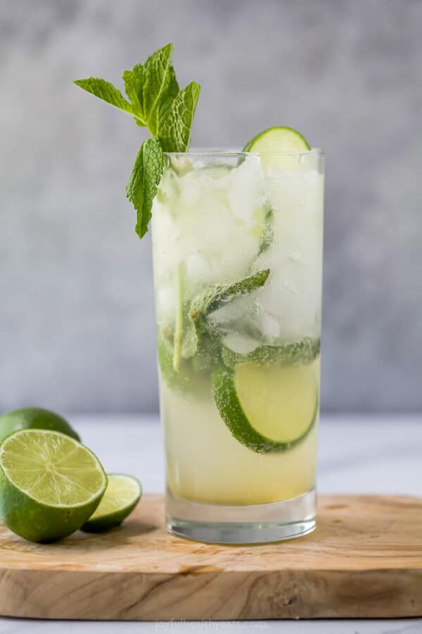 This Nojito recipe has everything you love about the original, minus the alcohol! Fresh mint, lime and sparkling water make it so refreshing. Nojito in glass on wooden cutting board with cut lime