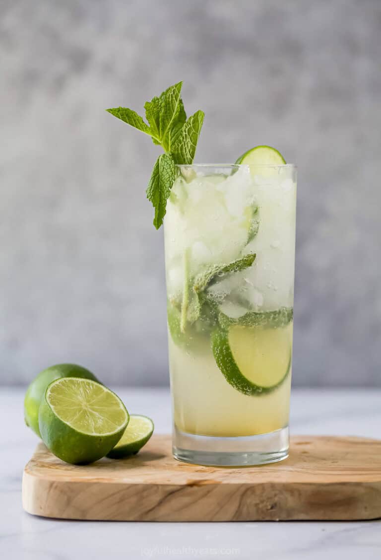 Nojito in glass on wooden cutting board with cut lime