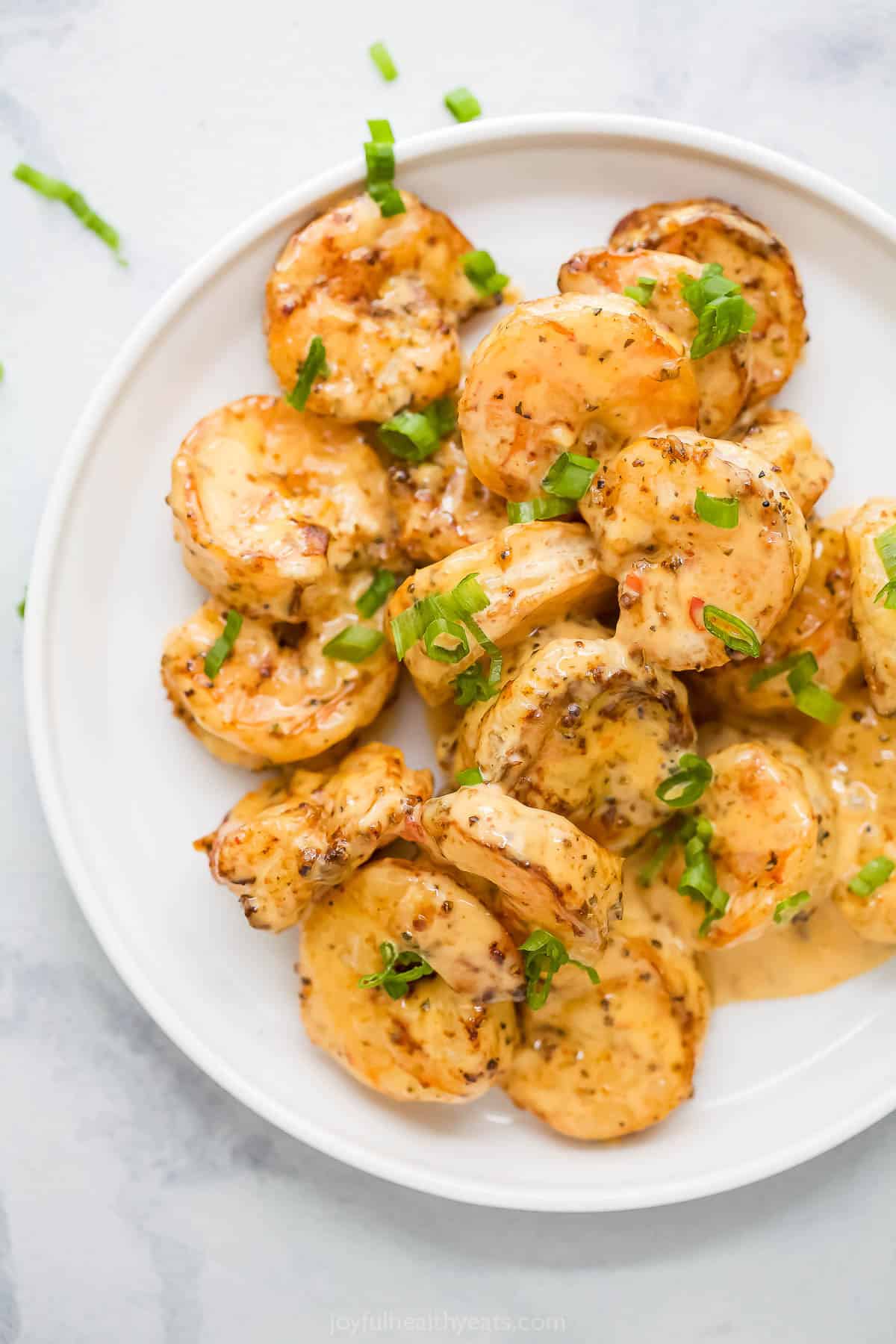 The air fryer makes this crispy Bang Bang Shrimp recipe super easy and lighter, and a creamy, spicy sauce makes it irresistible! Overhead view of bang bang shrimp on plate