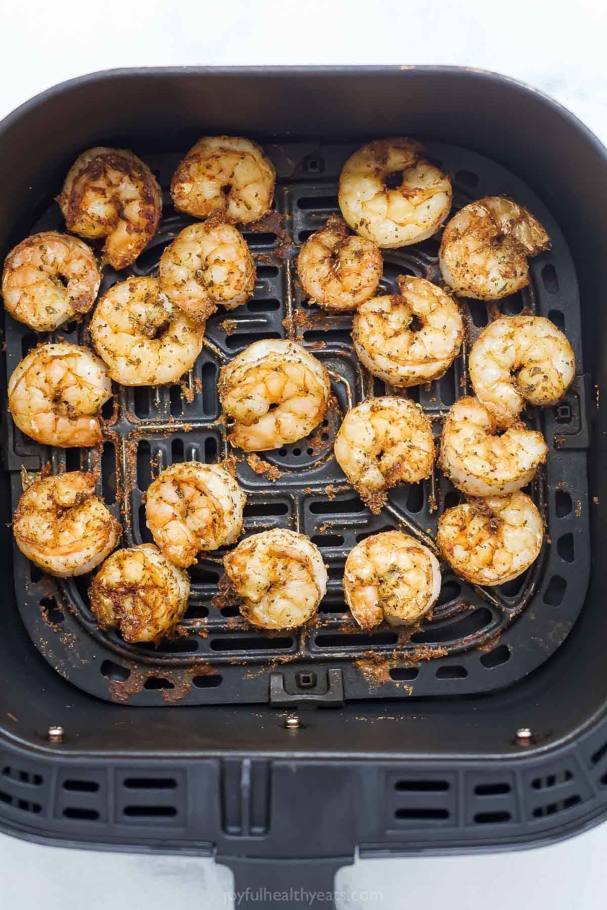 The air fryer makes this crispy Bang Bang Shrimp recipe super easy and lighter, and a creamy, spicy sauce makes it irresistible! Shrimp in air fryer basket