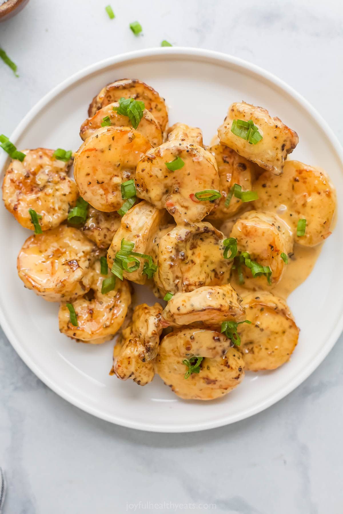 The air fryer makes this crispy Bang Bang Shrimp recipe super easy and lighter, and a creamy, spicy sauce makes it irresistible! Overhead view of crispy bang bang shrimp on plate