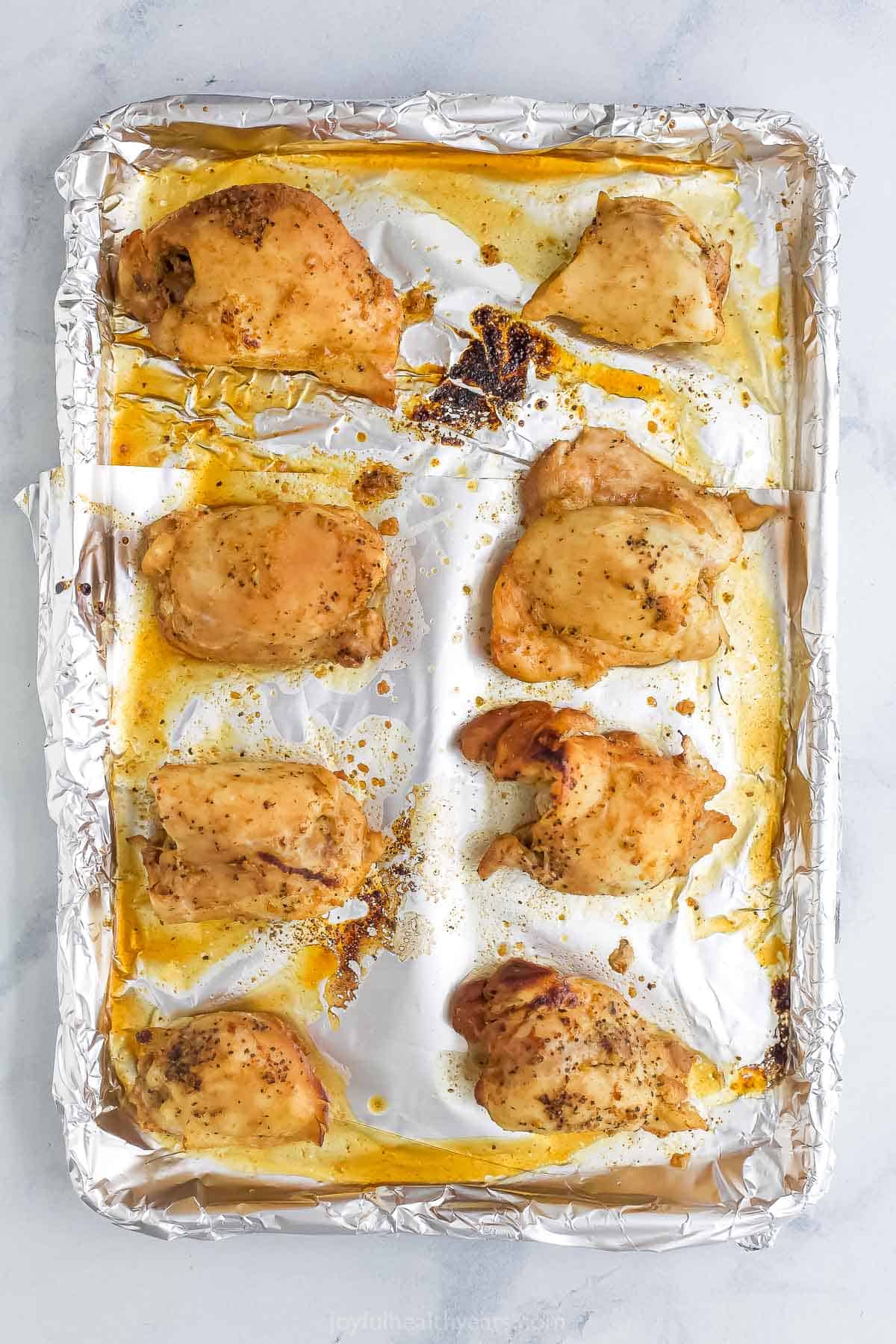 Overhead view of honey garlic chicken thighs on sheet pan