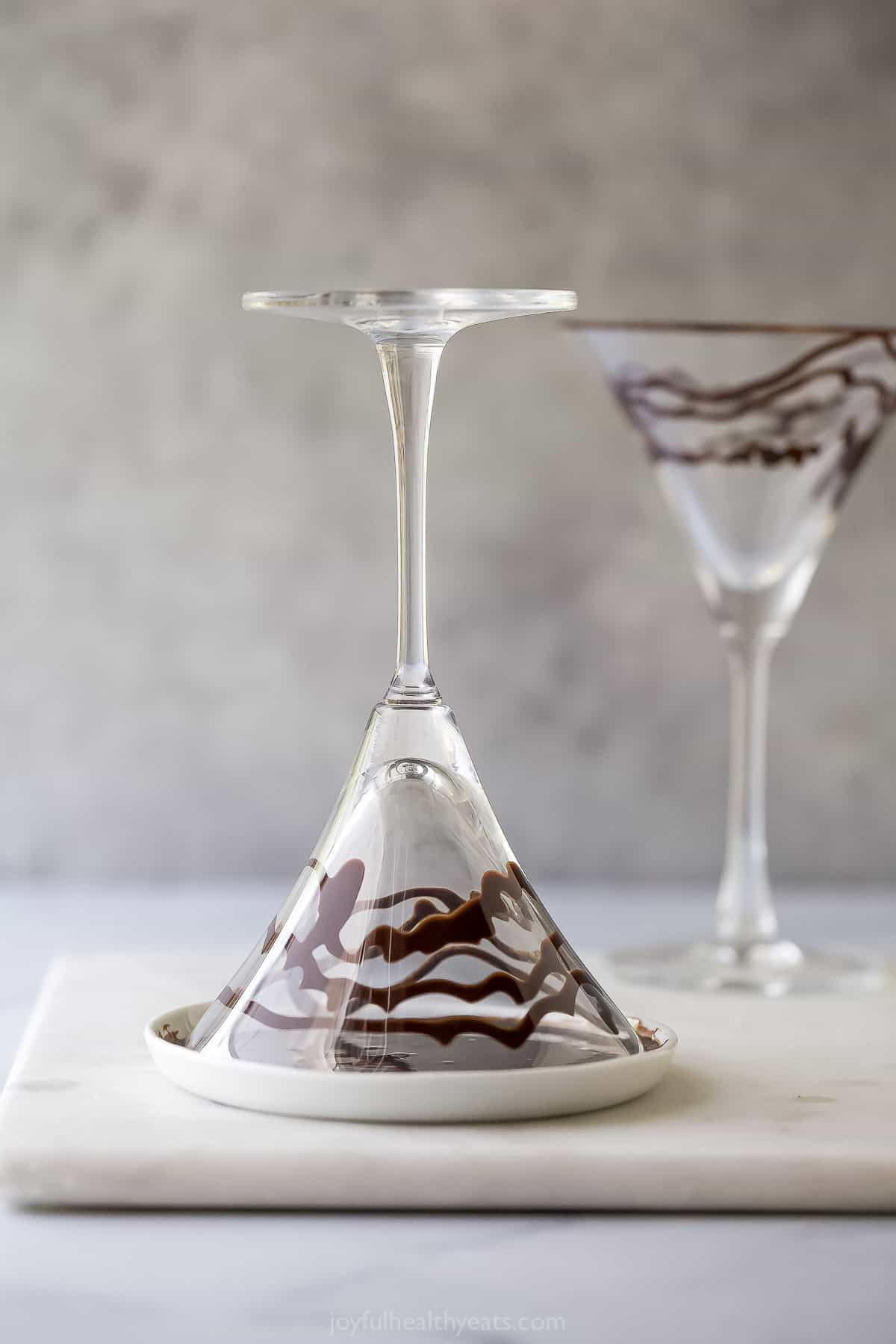 Rimming martini glass with chocolate syrup.