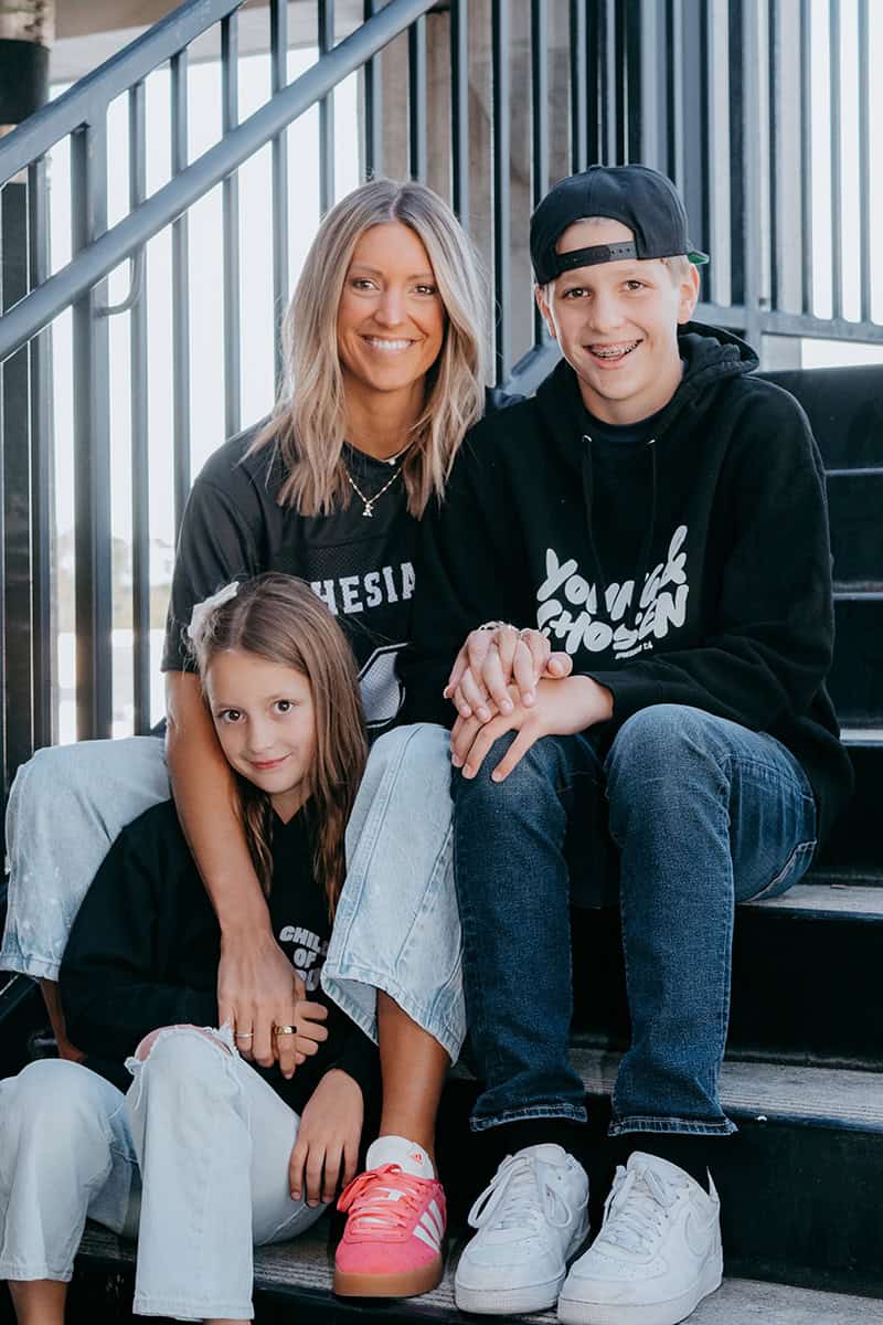 Photo of Krista Rollins with her children on stairs.